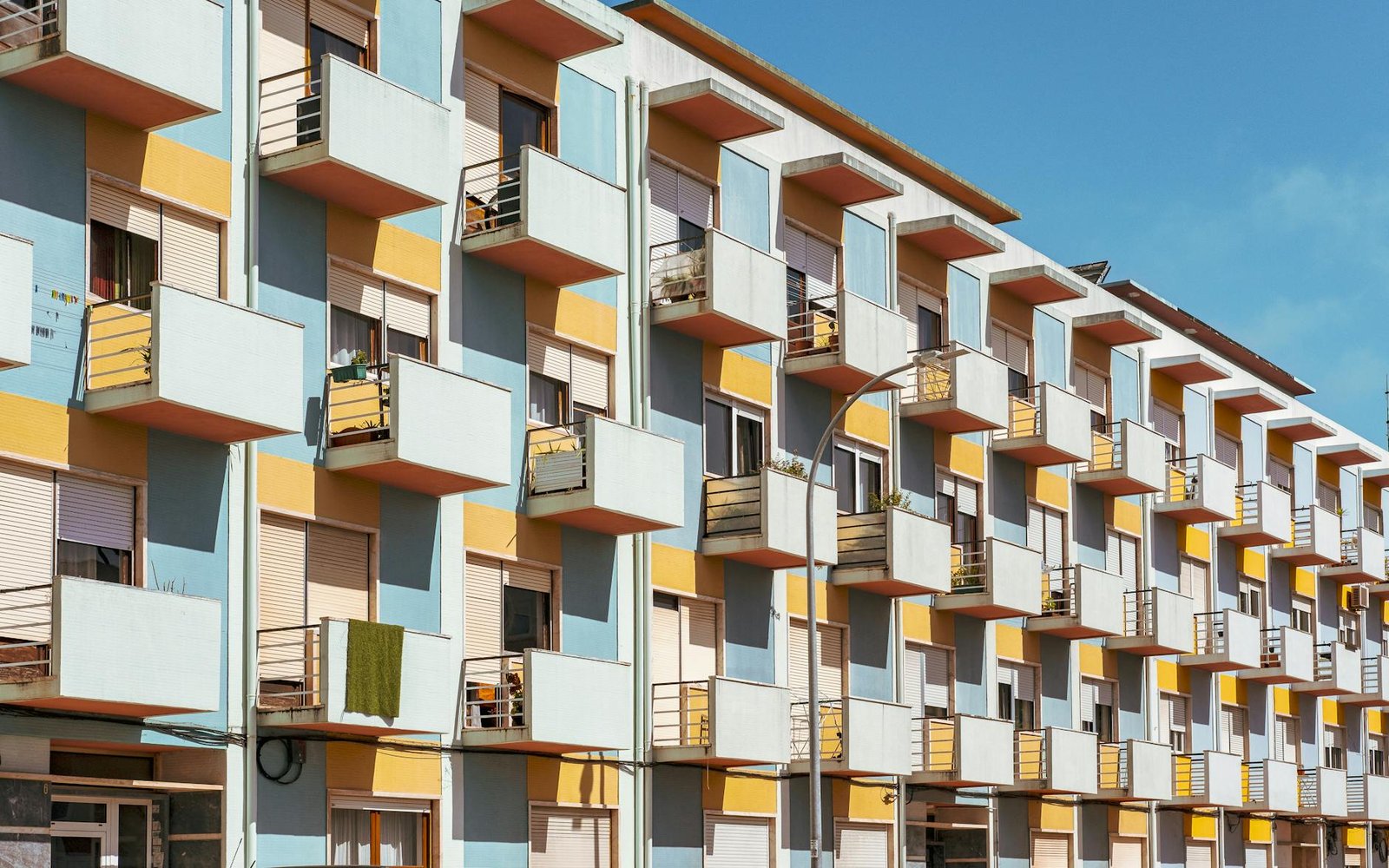 Vibrant apartment building facade in Mem Martins, Lisboa with repeating balconies.