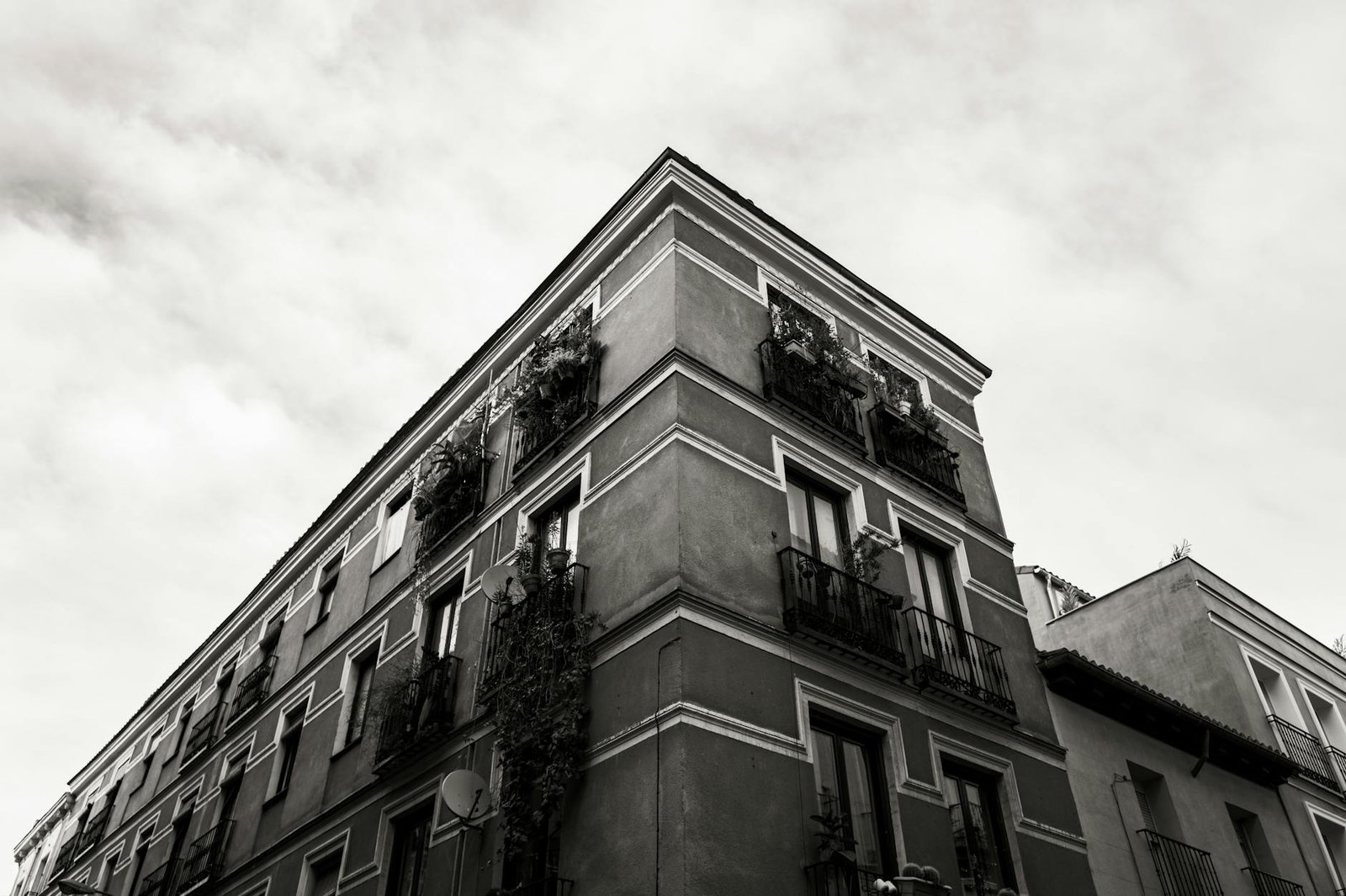 Black and white photo of a classic building in Madrid with a dramatic sky overhead.
