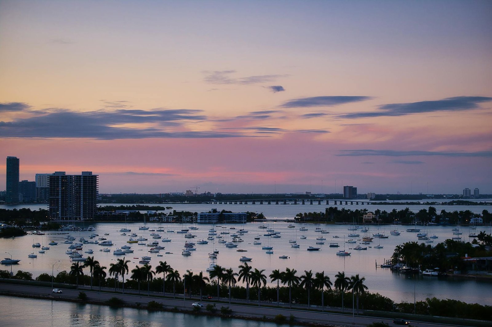 Aerial view of Miami harbor with boats and skyline during twilight.