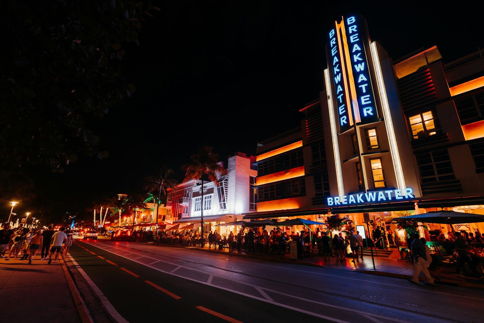 Vibrant nightlife scene in Miami's iconic Art Deco district with neon lights and crowds.