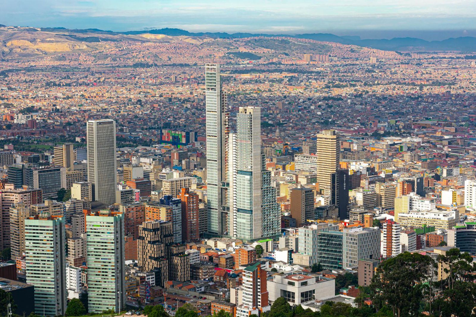 Aerial view of Bogotá skyline showcasing modern skyscrapers and cityscape under a clear sky.