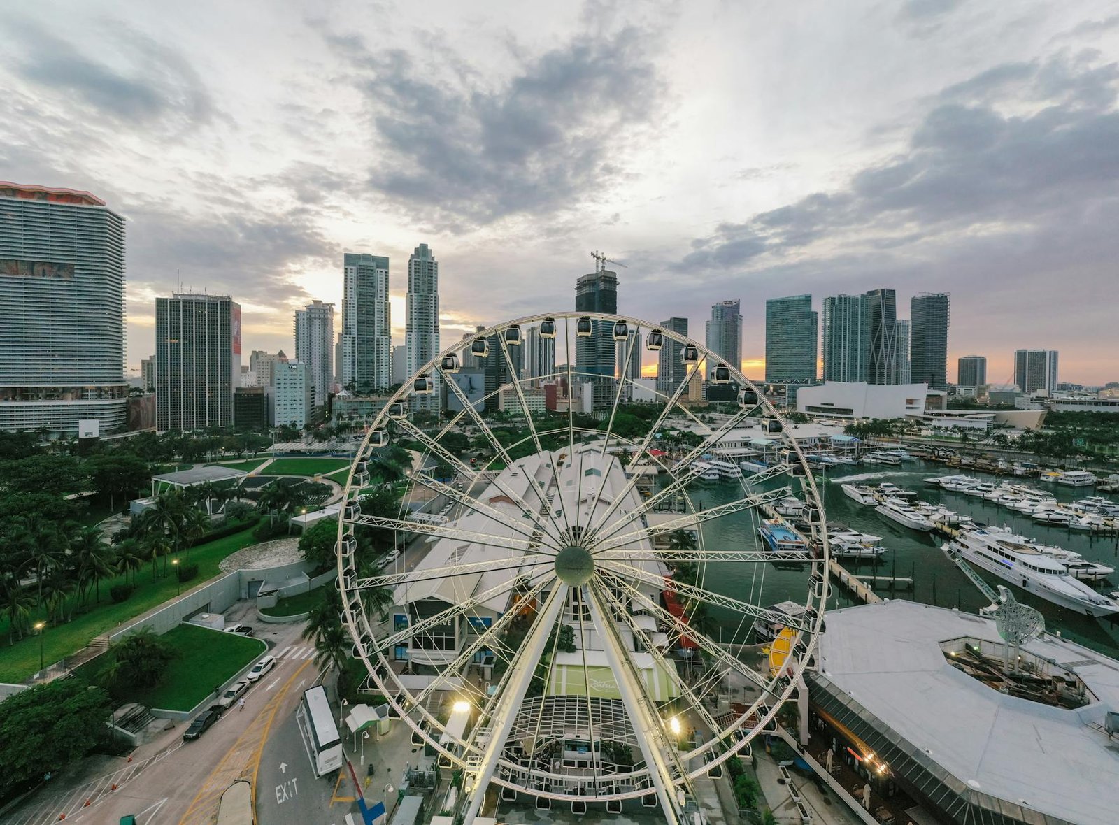 A breathtaking aerial view of Miami featuring a ferris wheel against the city skyline and harbor at sunset.